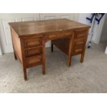 A good early C20th oak desk, single drawer, flanked by slides and three drawers on brass bound feet,