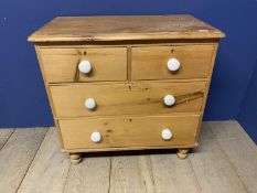 a pine chest of 3 long drawers with white knob handles