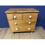 a pine chest of 3 long drawers with white knob handles