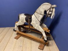 A C20th Rocking horse, grey dappled, on a swing base, and bears label Horse Play, Broad Hempston,