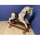 A C20th Rocking horse, grey dappled, on a swing base, and bears label Horse Play, Broad Hempston,