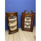 A corner display cabinet with bow front glazed door and key