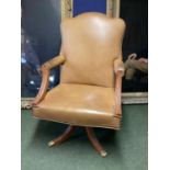 Large winged back light tan and studded brass leather arm chair, on 4 legs to castors