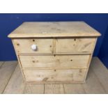 A pine chest of 2 short over 2 long drawers with white knob handles