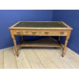 A faded mahogany writing table with shelf to base, and tooled green leather top, on turned legs to