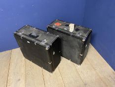 Two black vintage travelling square trunks