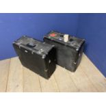 Two black vintage travelling square trunks