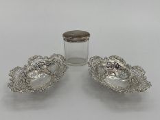 A pair of sterling silver pierced oval dishes, and a silver topped glass dressing table item