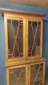 Two part faded mahogany and chequer board inlaid glazed bookcase; as found