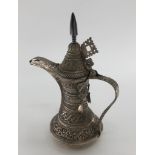An Indian /Omani style unmarked white metal coffee pot with floral decoration 503g, 25cm H