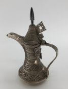 An Indian /Omani style unmarked white metal coffee pot with floral decoration 503g, 25cm H