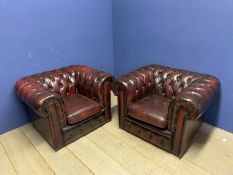 Pair of red leather buttoned back large arm chairs, some wear