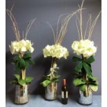 Three faux flower arrangements, white amaryllis, in contemporary circular mirrored planters, set