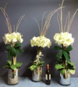 Three faux flower arrangements, white amaryllis, in contemporary circular mirrored planters, set