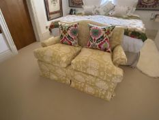 Small traditional two seater sofa, with loose cushions upholstered in a gold and cream patterned