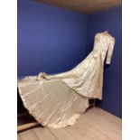 White slipper satin wedding dress with train cut as one with the skirt