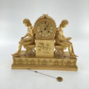 Gilded French mantle clock, flanked by figures of Grecian women sat on Regency style cross stretcher