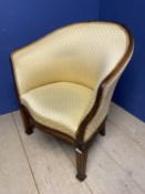 A mahogany framed tub chair, upholstered in a worn yellow fabric, some repair needed