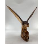 A wooden and resin model of a swooping Eagle on a tree stump (wing detachable) 74 cm x 75 cm x 32 cm