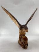 A wooden and resin model of a swooping Eagle on a tree stump (wing detachable) 74 cm x 75 cm x 32 cm
