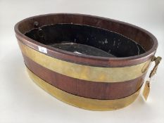 A wooden and brass bound planter with tin interior