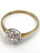 A 9ct gold diamond flower ring set with seven brilliant cut diamonds, 1.1g, size M