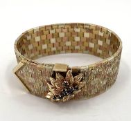 A 9ct gold Tri coloured buckle bracelet, with cast leaf and sapphire clasp, 19cm, 80g