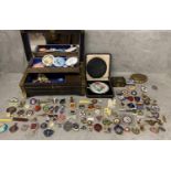 A large collection of C20th collectable and school badges in a brass bound casket with two compacts
