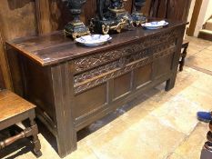 An C18th and later heavy oak plank coffer, with carved front panels and frieze, and bears date 1666,