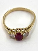 An 18ct gold ruby and diamond ring single oval free cut ruby with brilliant cut diamond accents ,