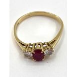 An 18ct gold ruby and diamond ring single oval free cut ruby with brilliant cut diamond accents ,