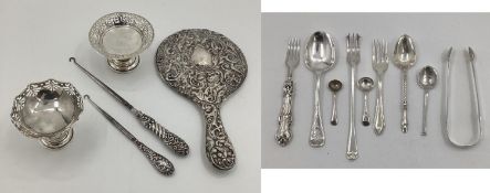 A collection of sterling silver and white metal items to include sugar tongs, pickle fork etc,