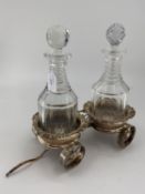 A silver plated decanter wagon with a pair of coasters having cast rims and turned wooden bases with