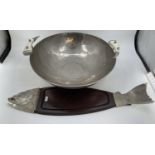 A very large beaten metal style bowl, and a large board styled with fish head and fins