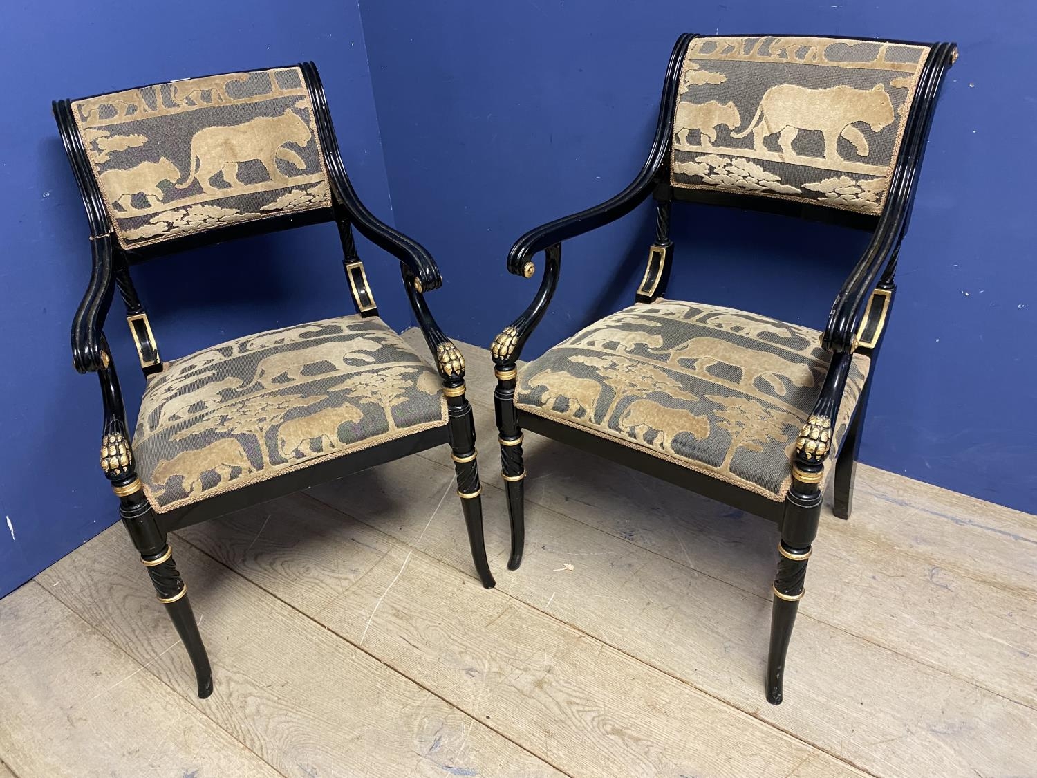 Pair of contemporary black and gilt armchairs, upholstered in an African Safari upholstery, one