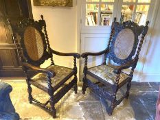 Pair of good Jacobean style heavily carved mahogany arm chairs, with bergere cane backs and