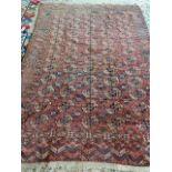 A large terracotta ground rug. 208 x 315cm, SOME RESTORATION NEEDED