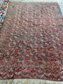 A large terracotta ground rug. 208 x 315cm, SOME RESTORATION NEEDED