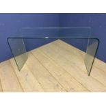 A contemporary glass side table, 125 W x 70cm high approx