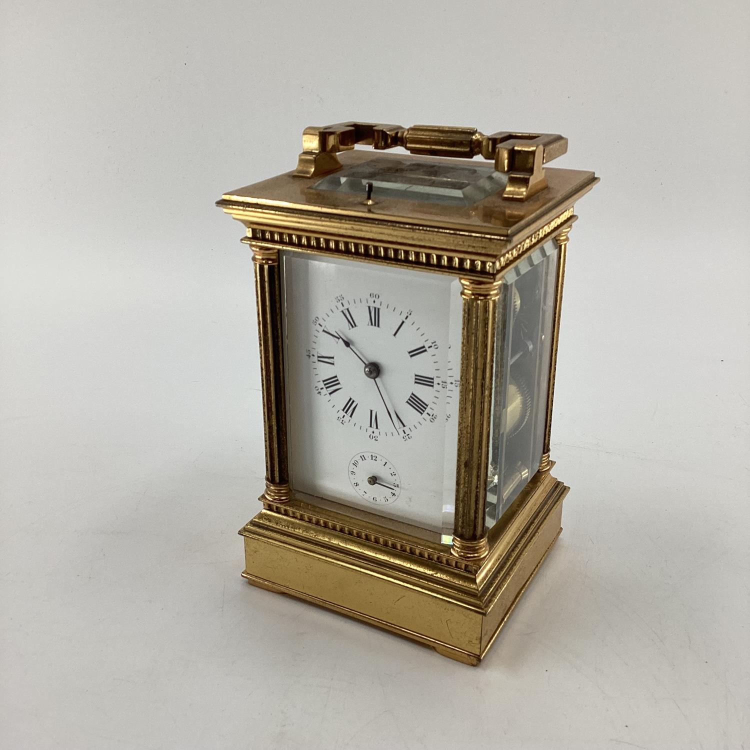 A gilt brass carriage clock, with five glass panels, striking on a gong.