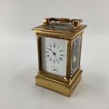 A gilt brass carriage clock, with five glass panels, striking on a gong.