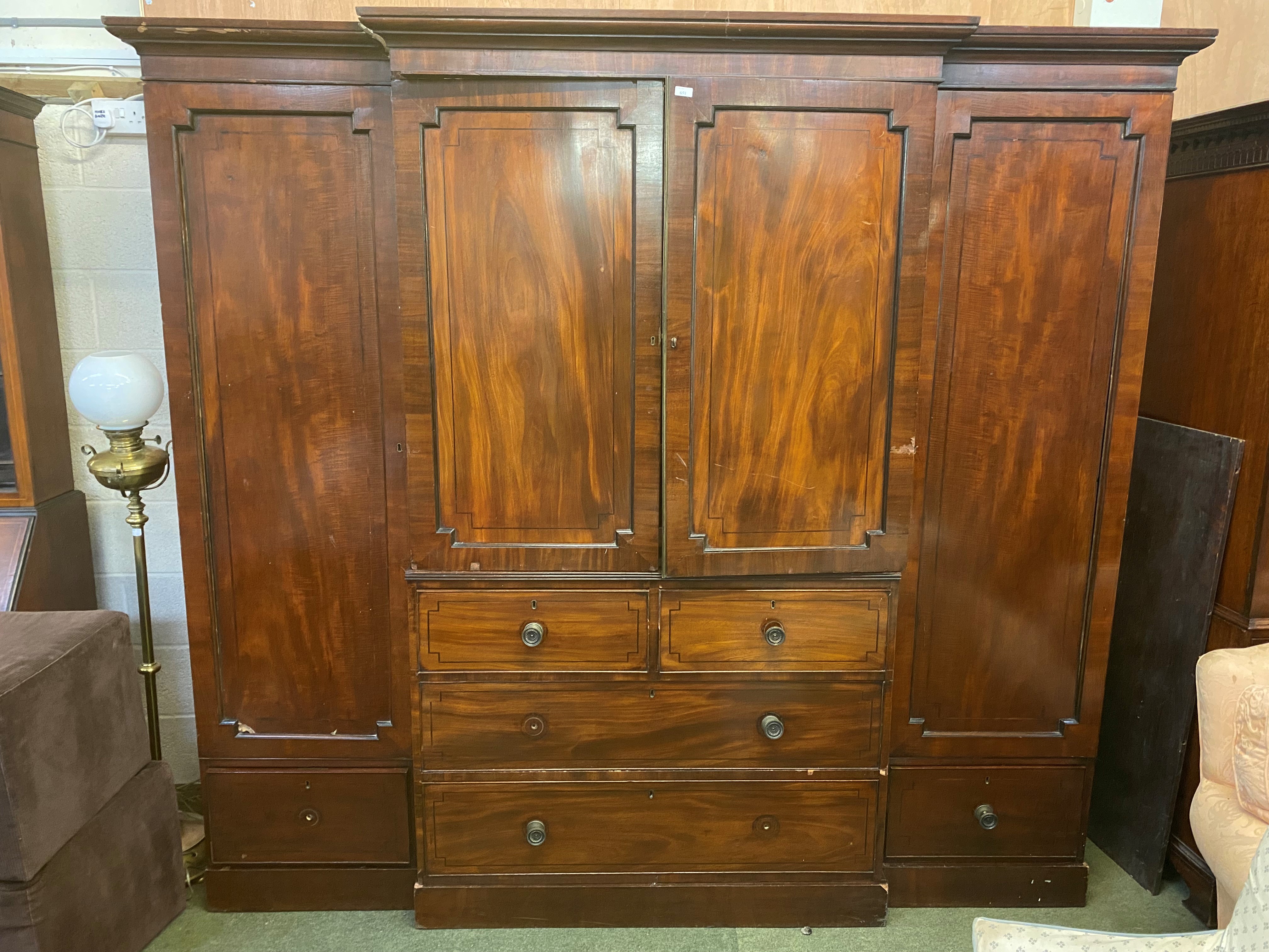 Victorian figured mahogany compactum, flanked by hanging cupboards, the central section with 4