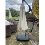 GARDEN FURNITURE: a very large garden parasol, on black all weather base/stand, with water hole to