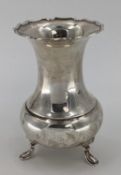 A sterling silver flower vase of bulbous form with flared rim raised on three feet by Atkin Bros