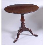 A George III mahogany pedestal tripod table, having a one-piece tilt-top to a baluster turned urn