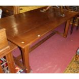 A contemporary joined oak plank topped refectory dining table, having cleated ends, raised on