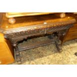 A late 19th century heavily carved oak centre table, having canted corners, single frieze drawer,