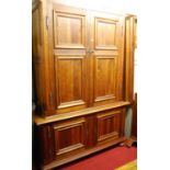 A large contemporary hardwood four door wardrobe, the twin upper doors enclosing hanging