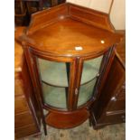 An Edwardian mahogany and chequer strung bowfront double door glazed corner cabinet, having platform