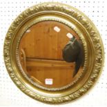 A floral embossed brass framed circular bevelled wall mirror, dia. 45cm